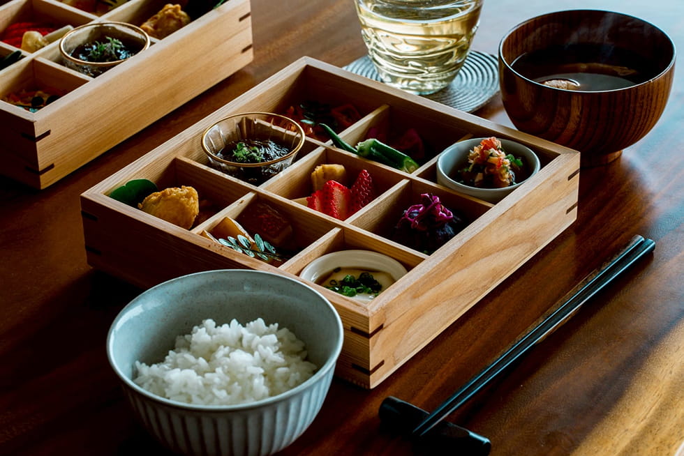 木箱に盛り付けられた小鉢料理と白ご飯の和朝食セット