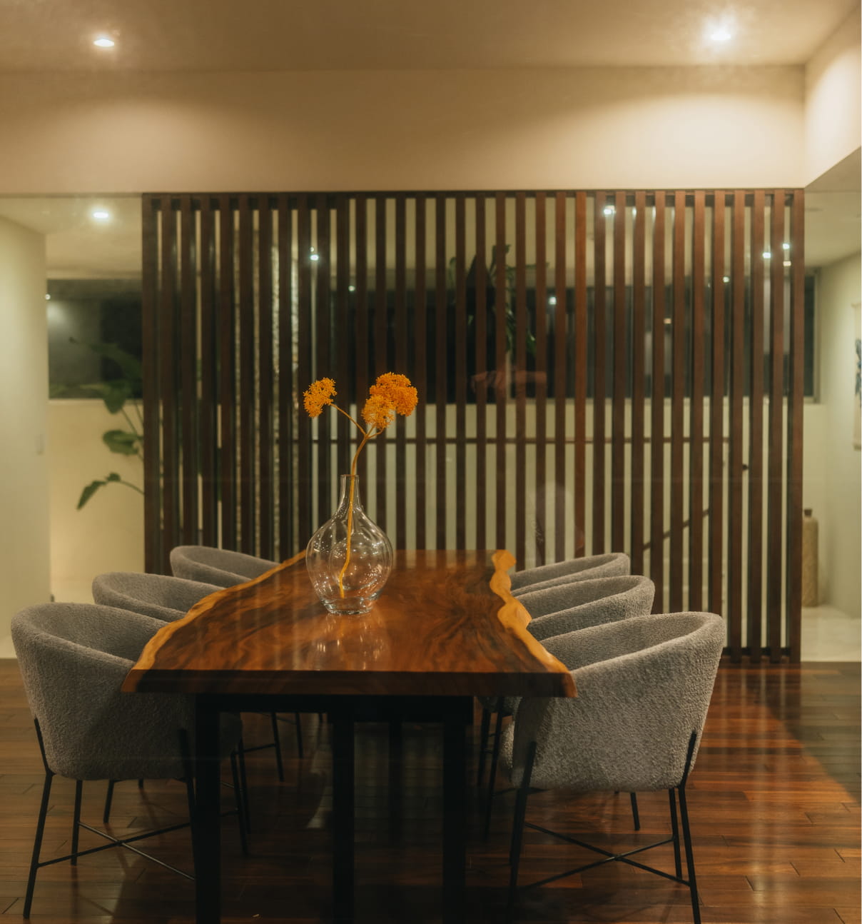 温もりある木のテーブルに花を飾った、極海静邸の静謐なダイニング空間